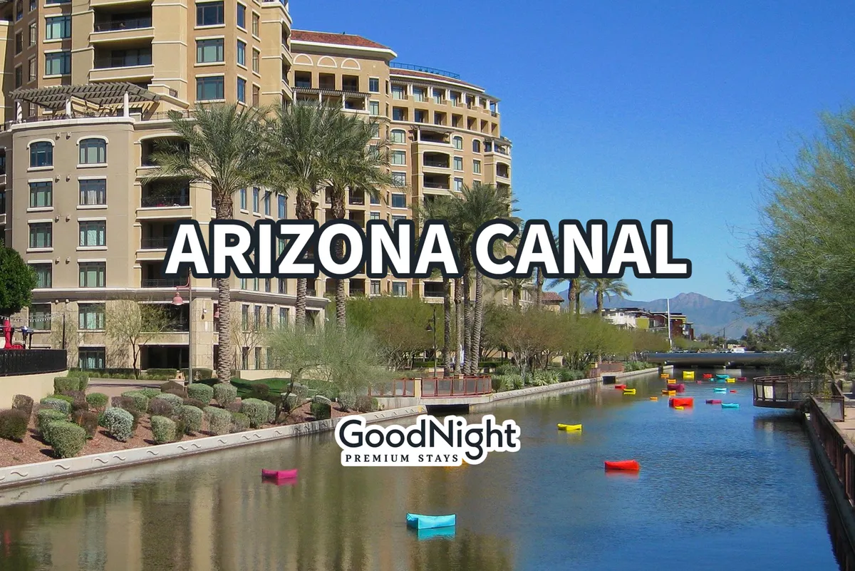 A picturesque view of the Arizona Canal, featuring colorful boats, palm trees, and distinctive architectural details along the waterfront. The scene is bright and inviting, highlighting outdoor recreation, walkability, and a vibrant community atmosphere.